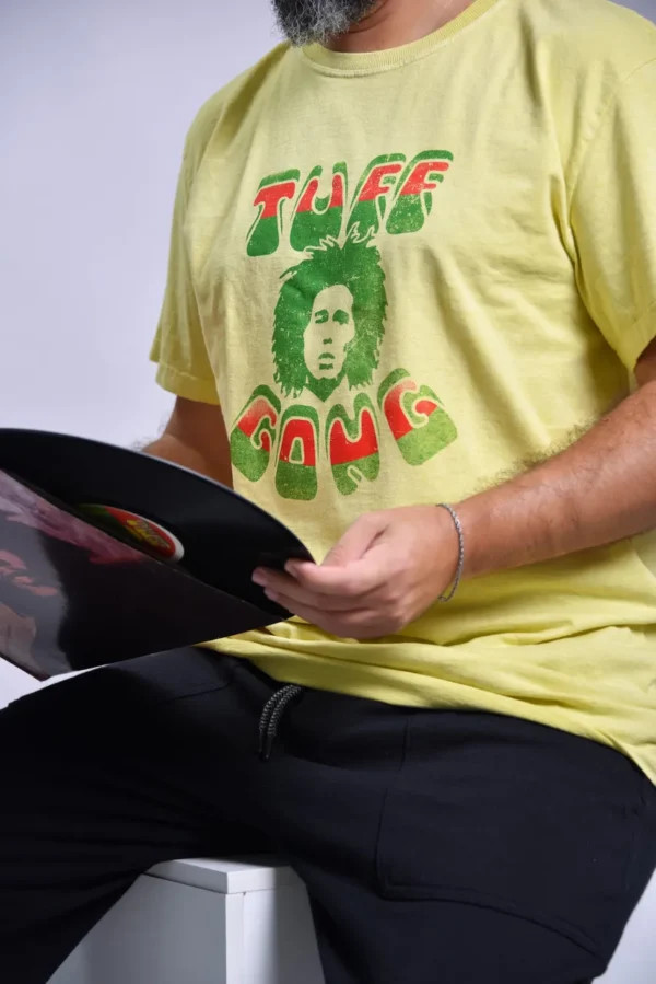 T-shirt com o rosto do Bob Marley e a cima esta escrito uff e a baixo Gong a parte da frente de cor amarela