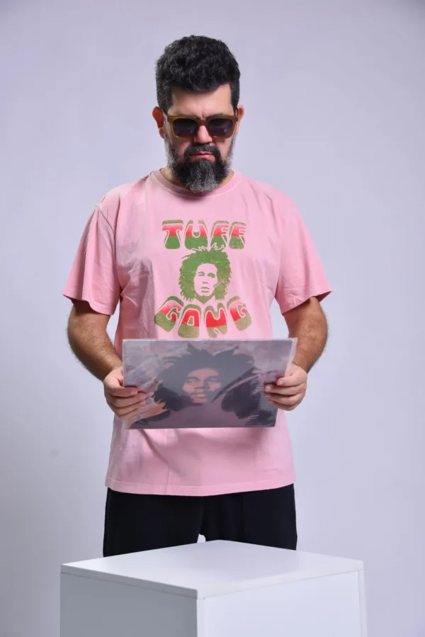 T-shirt com o rosto do Bob Marley e a cima esta escrito uff e a baixo Gong a parte da frente de cor rosa