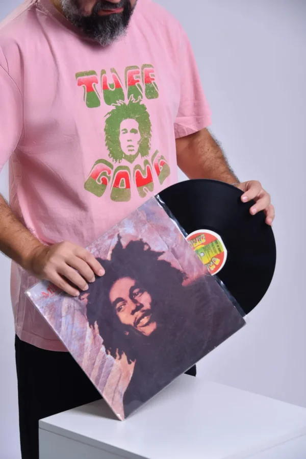 T-shirt com o rosto do Bob Marley e a cima esta escrito uff e a baixo Gong a parte da frente de cor rosa