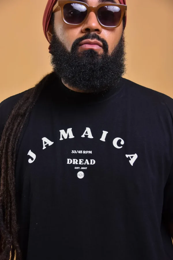 T-shirt com a palavra Jamaica na frentee a palavra Dread abaixo e com um detalhe dabandeira da jamaica na parte de baixo